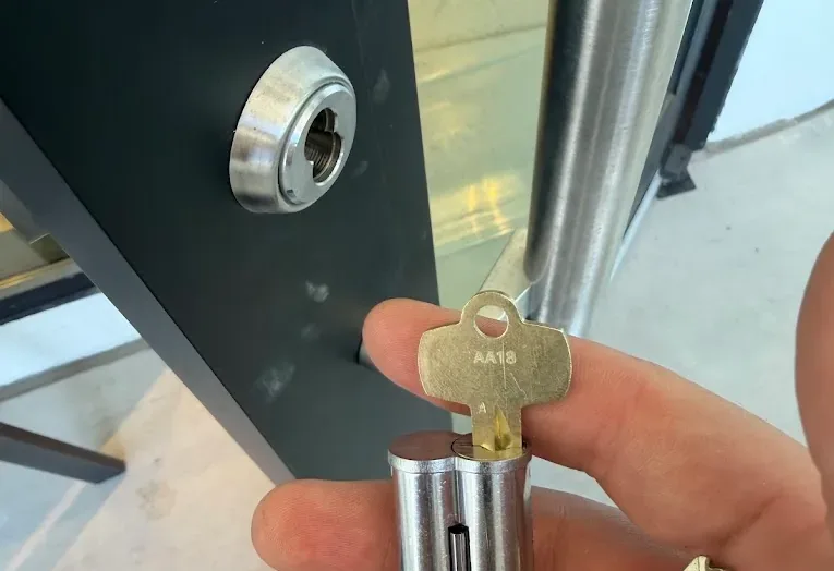 A new lock cylinder and key being fitted to a door.