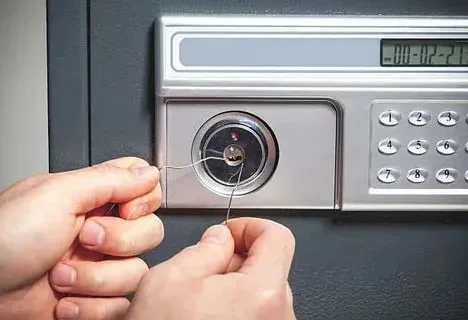 A hand operating a safe dial lock.