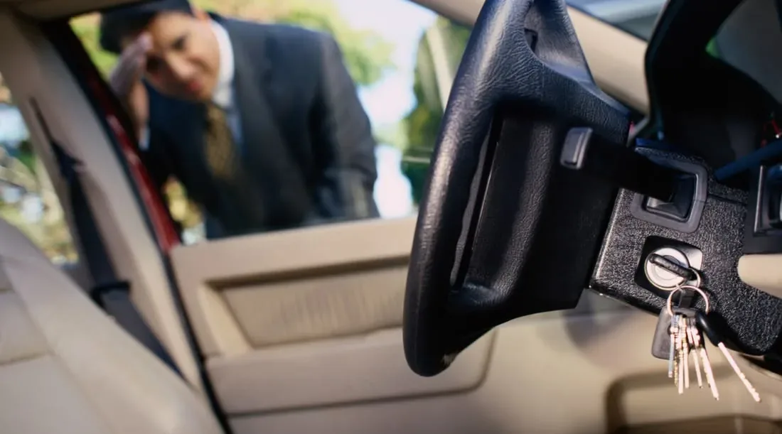 A locksmith assisting at an open vehicle door.