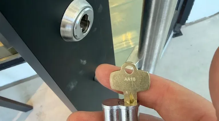 A new lock cylinder and key being fitted to a door.