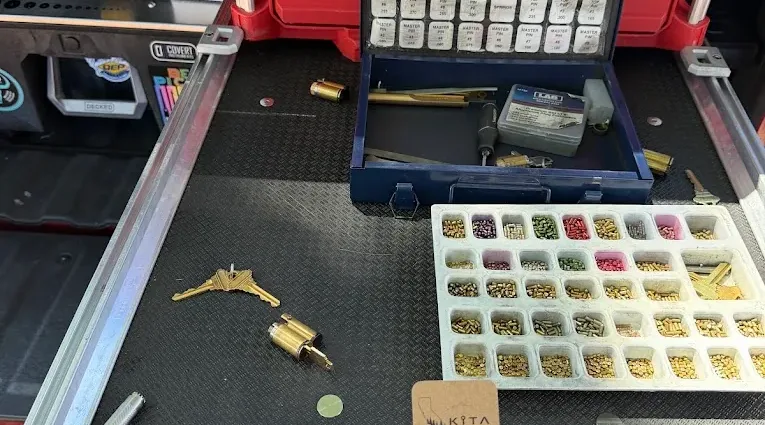 Locksmith rekeying work with key pins and cylinders in a service workspace.