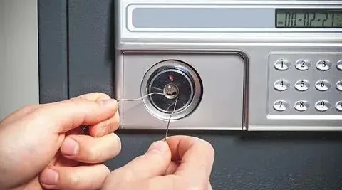 A hand operating a safe dial lock.