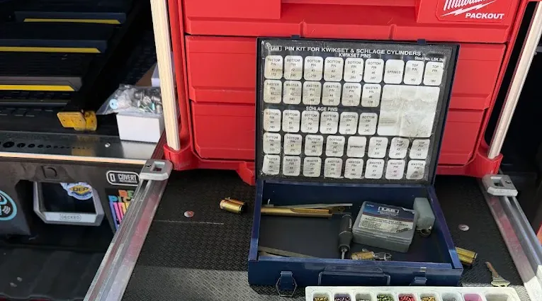 Locksmith pin kit and rekeying supplies arranged in a mobile work vehicle