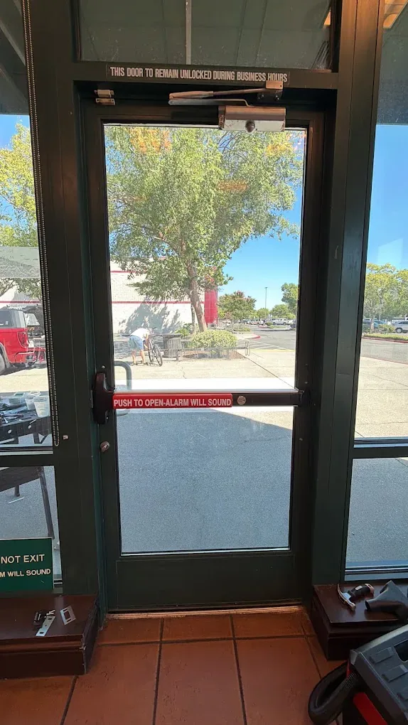 Glass door and metal lever at an exterior entrance.
