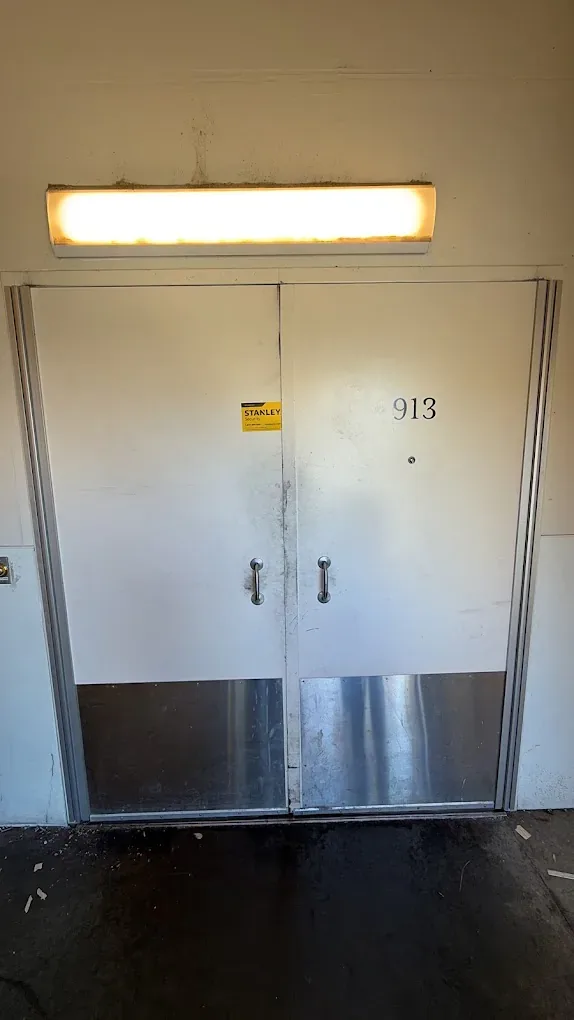 Exit door with a horizontal panic bar inside a commercial building.