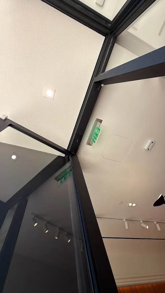Technician using a ladder to work near a commercial doorway.