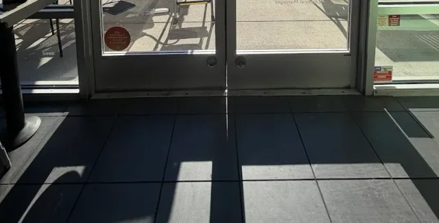 Door handles and lower glass panels on a commercial entry.