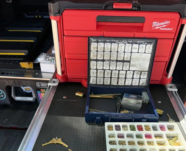 Locksmith pin kit and rekeying supplies arranged in a mobile work vehicle.