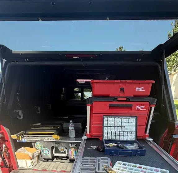 Locksmith key and pinning equipment arranged inside an open service truck.