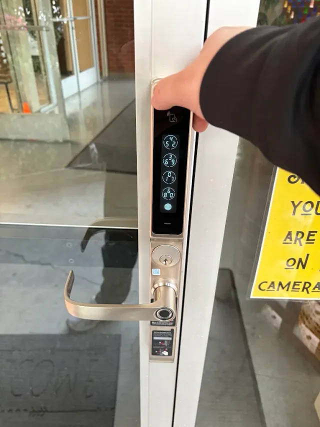 Digital keypad and lever lock on a glass entrance door.
