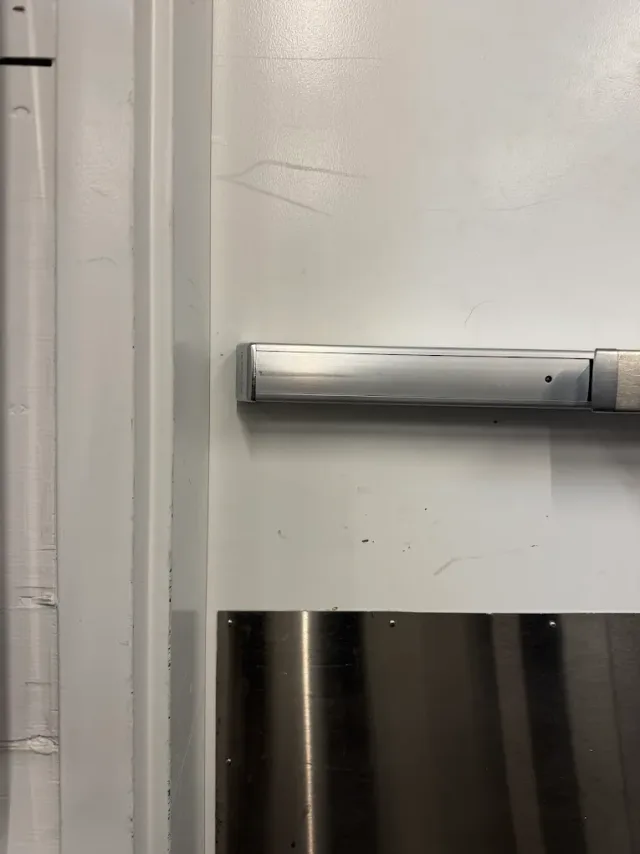 Close-up of panic hardware on a metal commercial door.